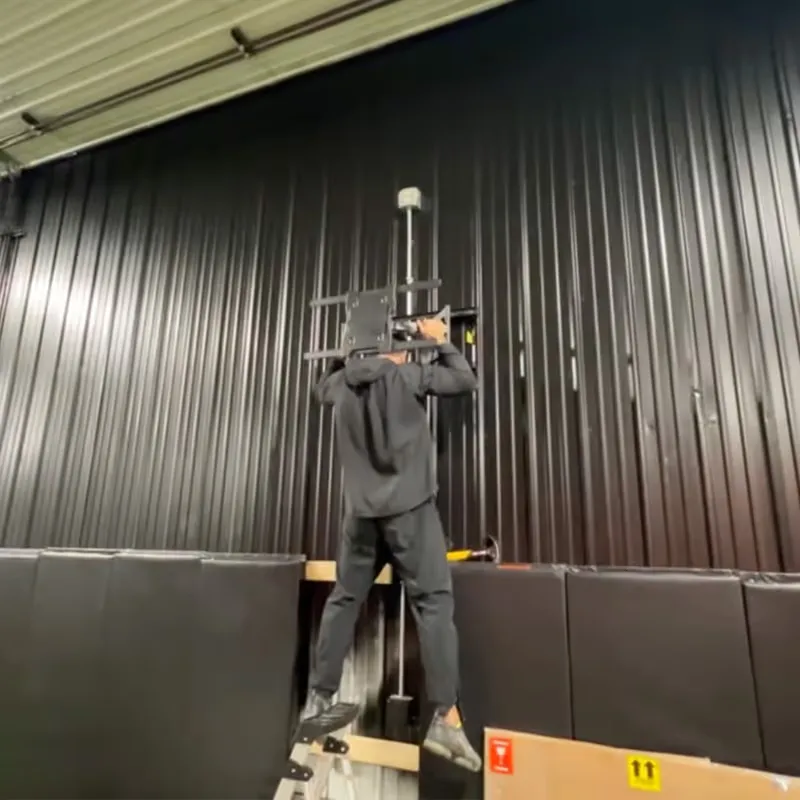 An 86-inch TV on a full-motion mount about 12 feet up at a training facility