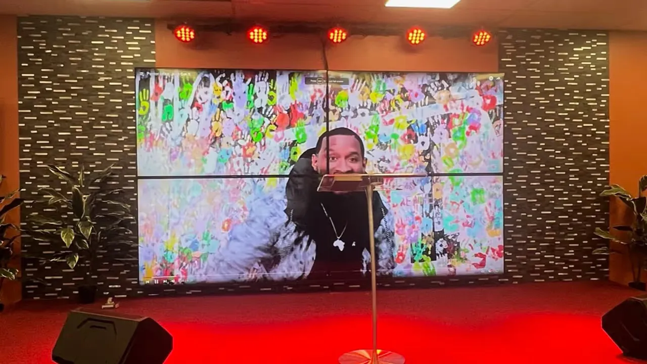 Four 55-inch TVs installed as one video wall in a church