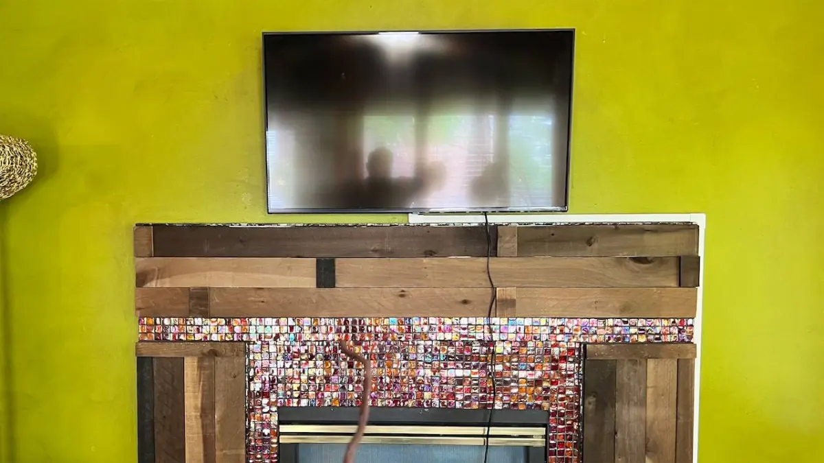 43-inch TV mounted above fireplace on plaster wall in Plymouth with exterior cord concealing