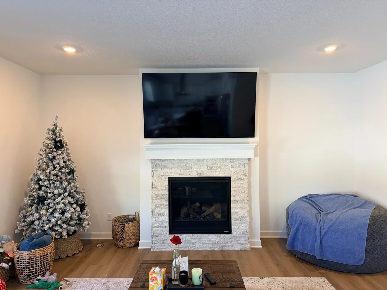 75-inch Sony TV mounted above fireplace with tilt bracket in Waconia