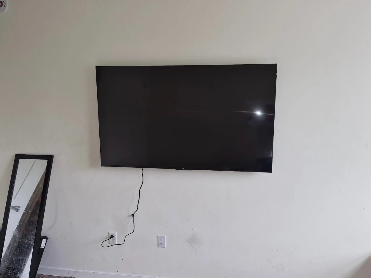 65-inch TV with tilt bracket mounted on drywall in downtown Minneapolis apartment