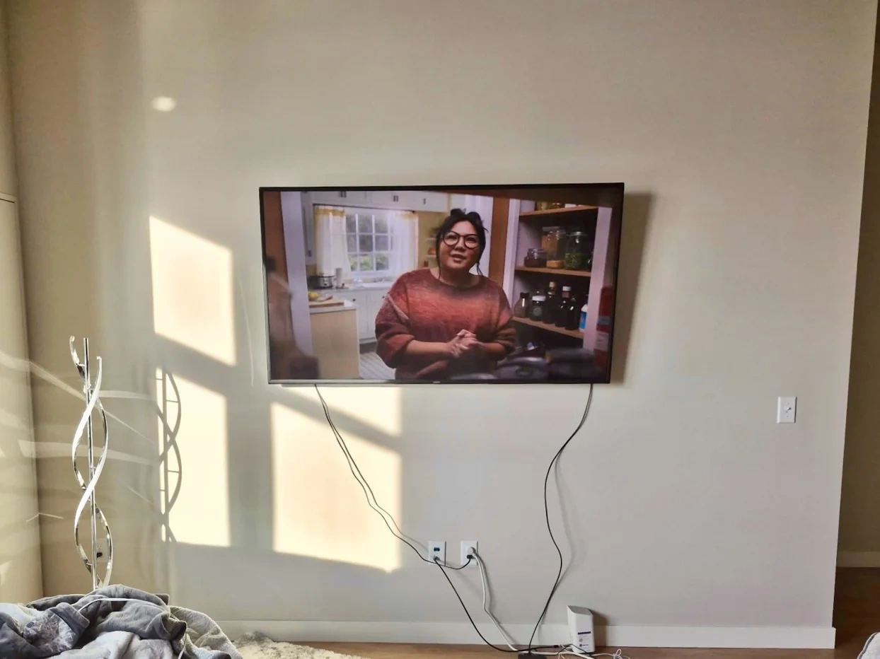 65-inch TV mounted on drywall with tilt bracket on Portland Avenue