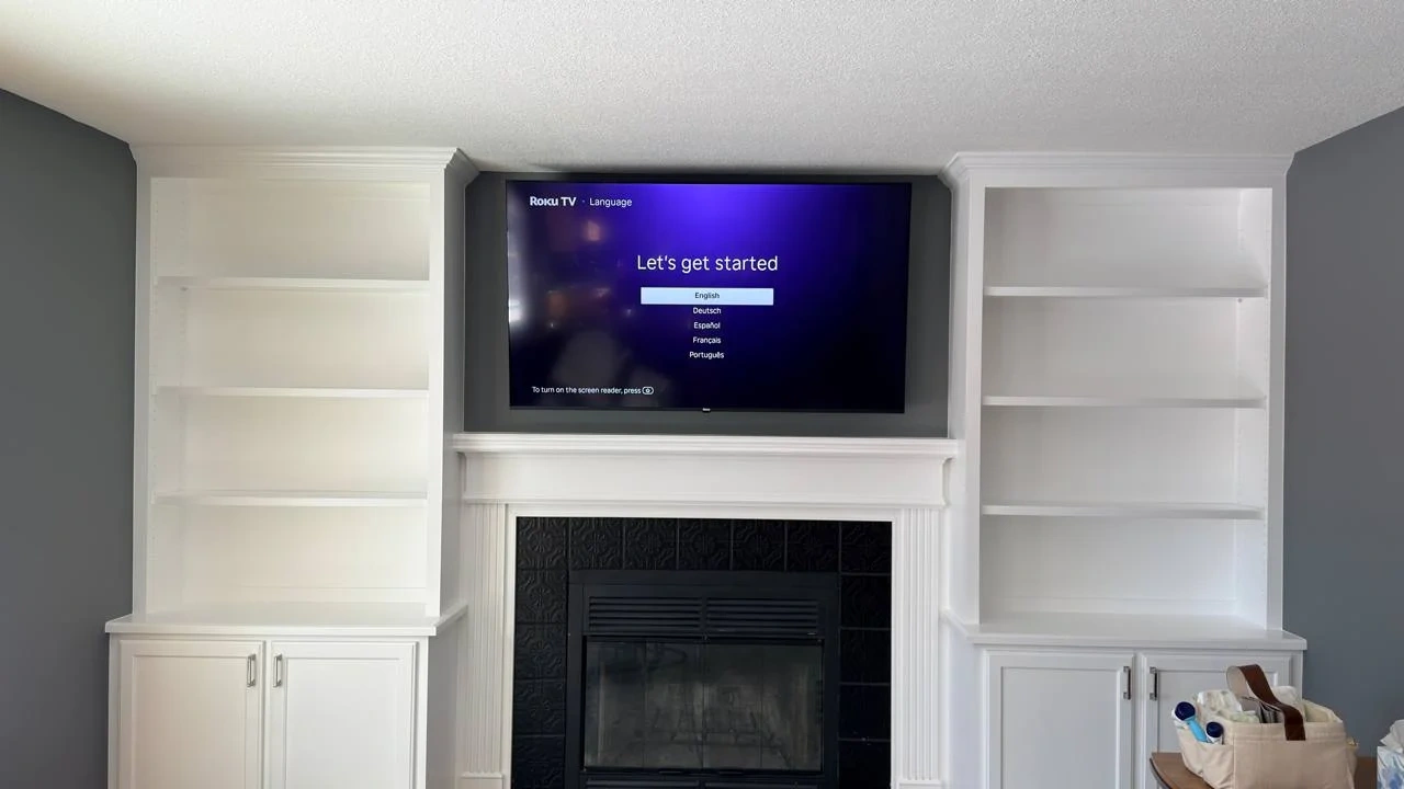 65-inch Samsung Frame TV mounted above fireplace in Plymouth Minnesota with custom built-in cabinetry