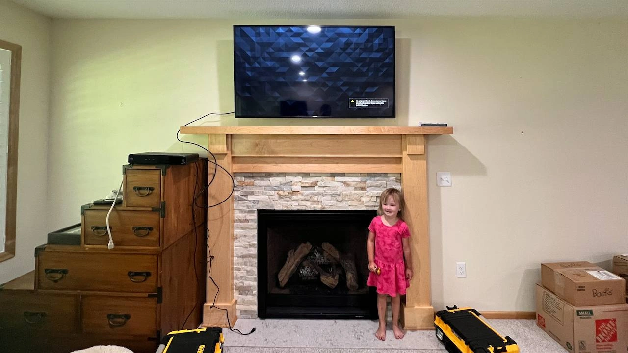 65-inch TV mounted above fireplace in Plymouth home with family-friendly installation