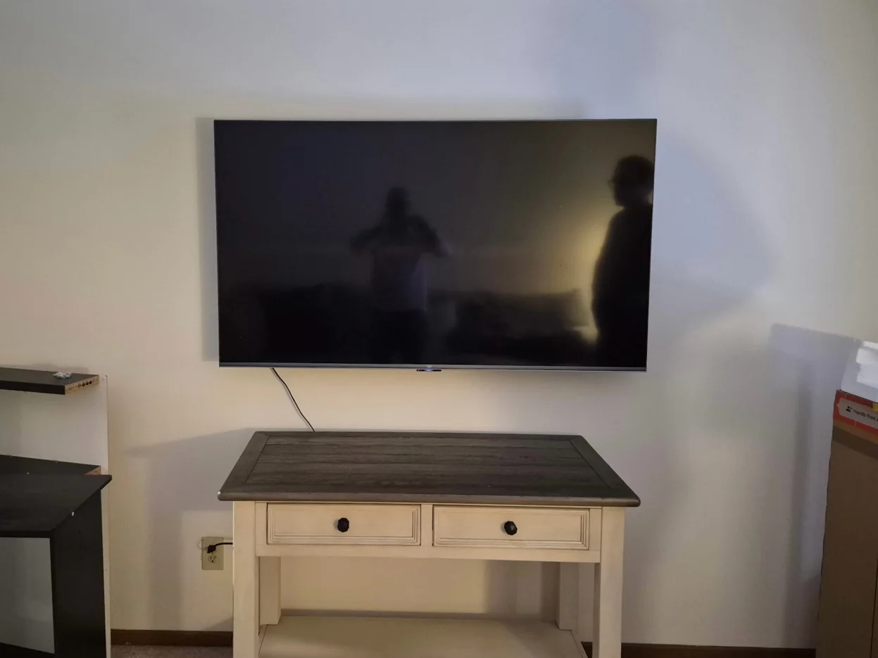 65-inch TV mounted on drywall with tilt bracket in Bloomington apartment