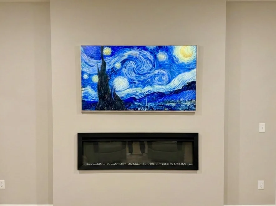 65-inch TCL NXTFrame gallery-style TV flush mounted on drywall with recessed outlet in Maple Grove