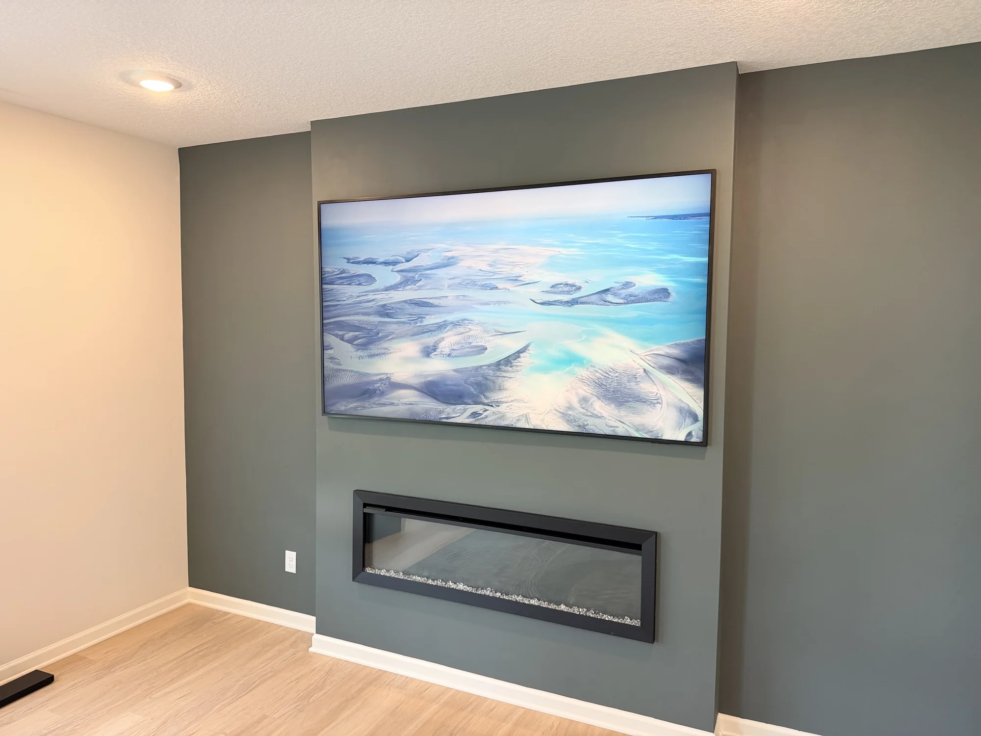 85-inch Samsung Frame TV mounted above an electric fireplace in Cottage Grove