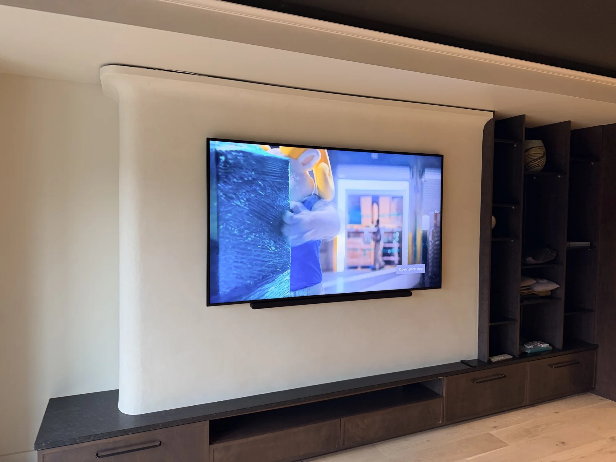 75-inch Samsung Frame TV with a soundbar mounted below on a curved feature wall in Minneapolis